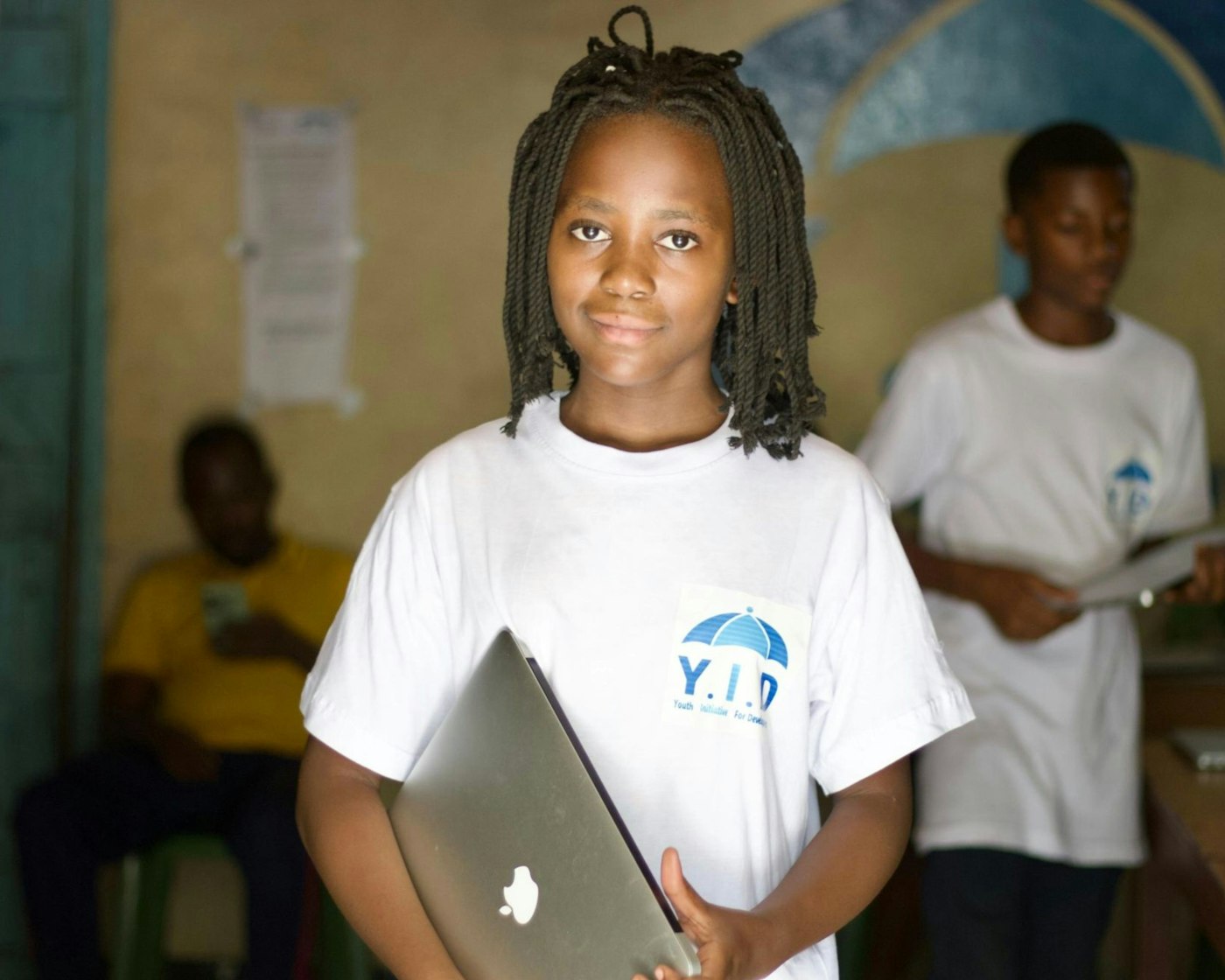 Child coding on a laptop in class with a proud grin