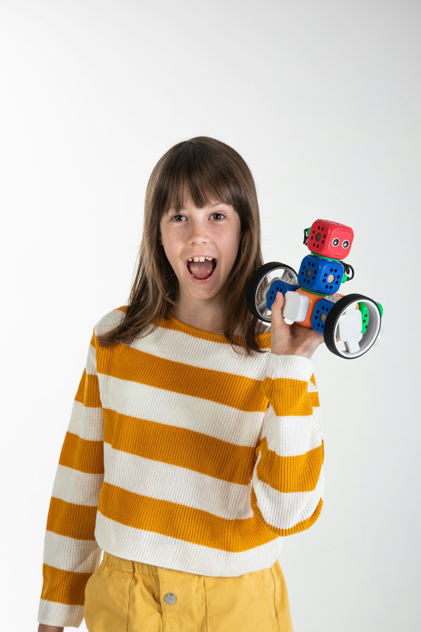 Student proudly holding up a finished build-block robot