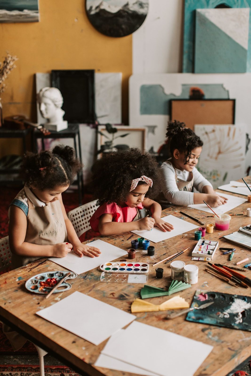 Girls painting with watercolours at an art table