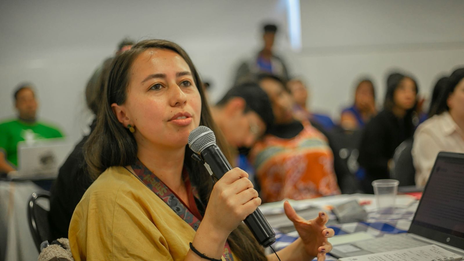 Student speaking into a microphone in front of the class