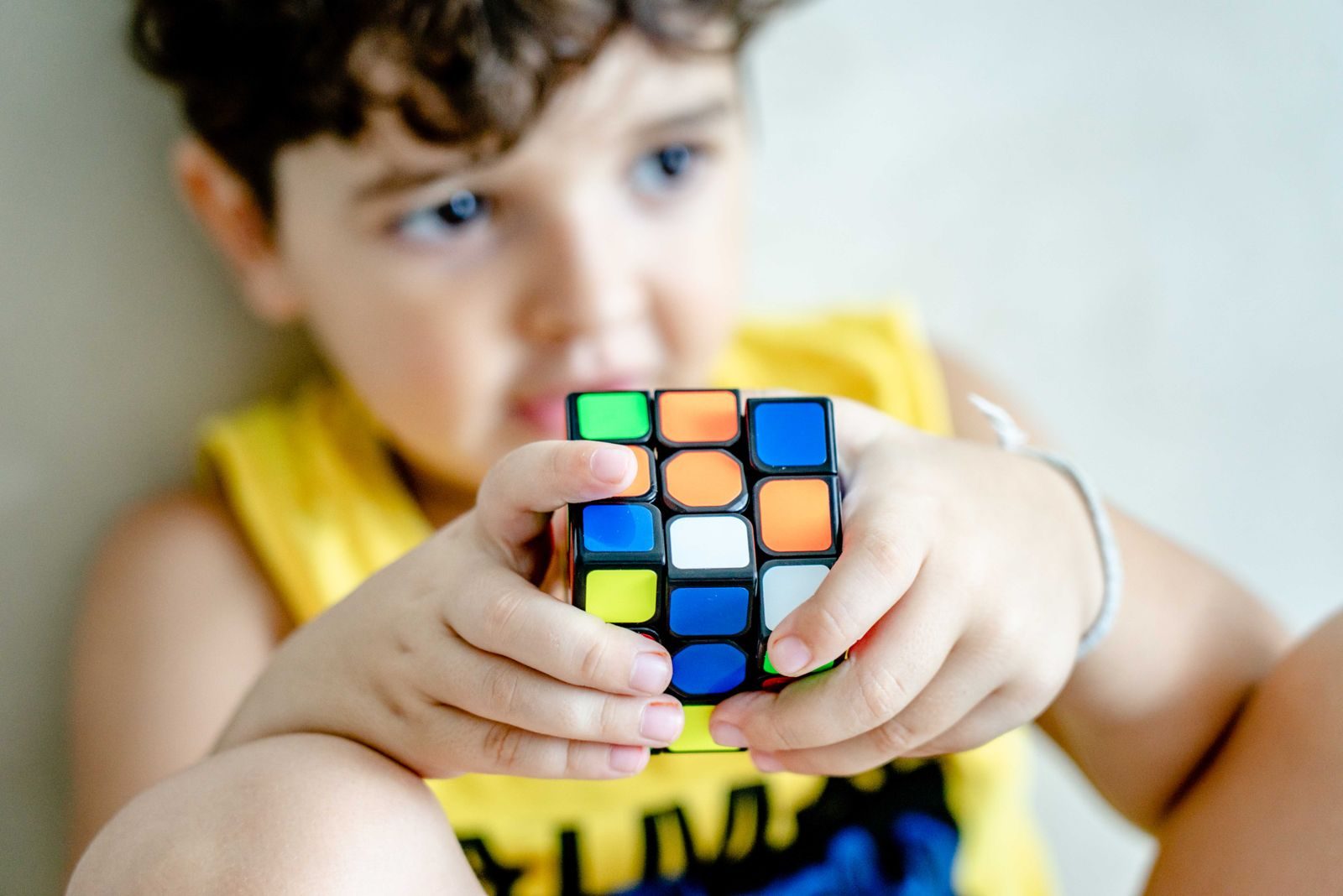 Boy holding a Rubik's cube up close while solving