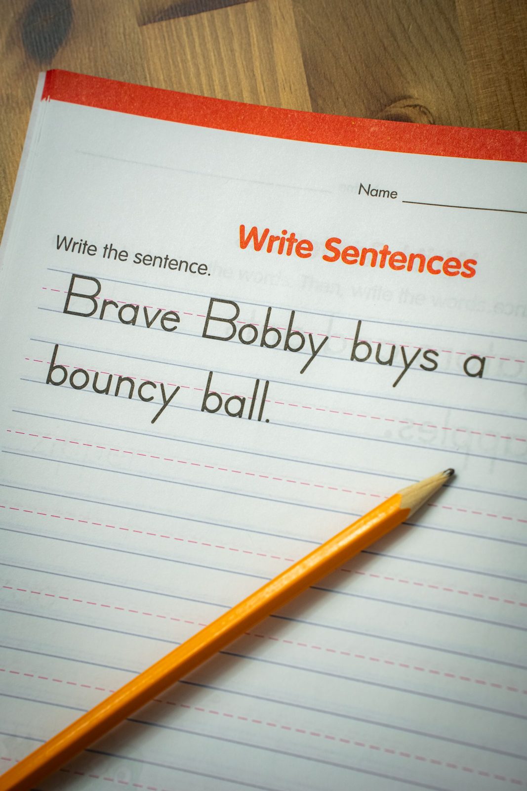 Sentence writing practice in a lined workbook