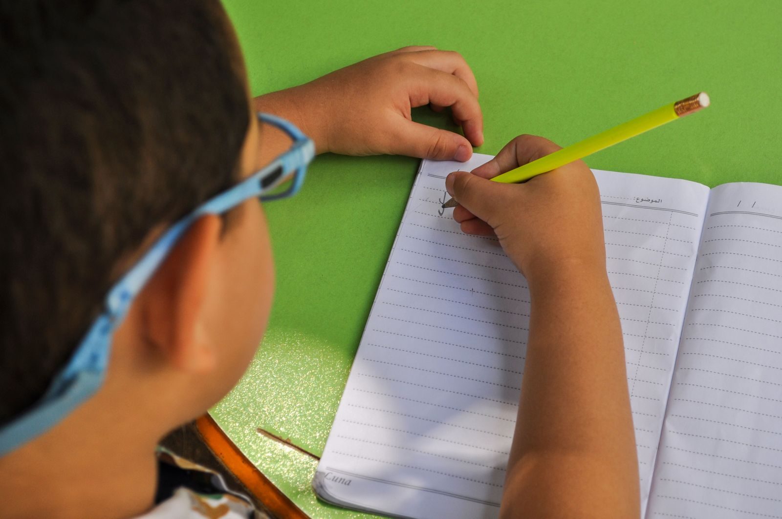 Child writing words carefully in a notebook