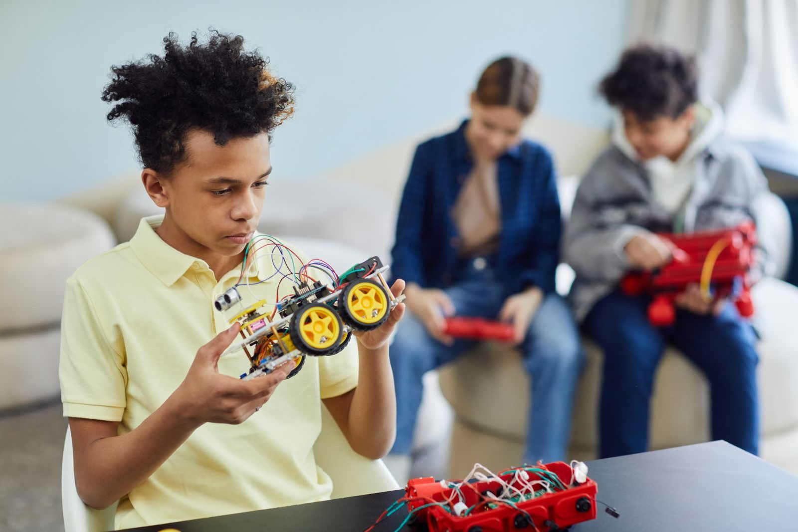 Student holding up a self-built robotic car