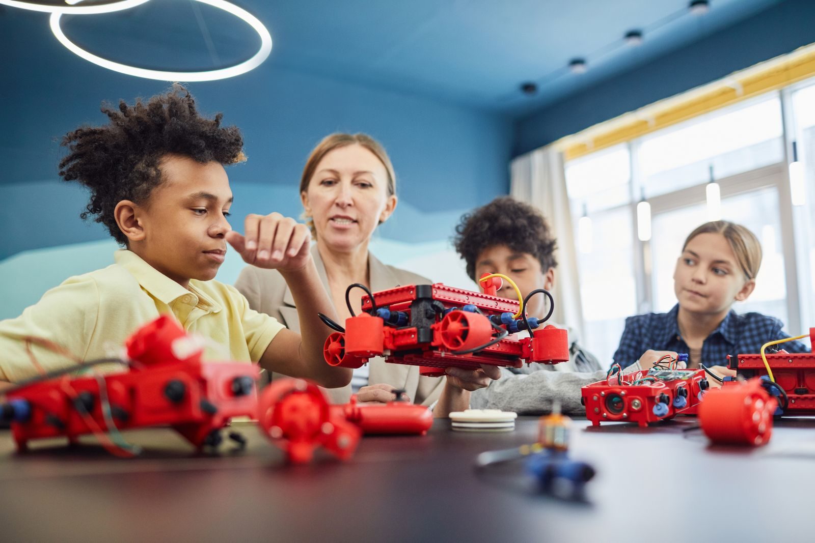 Coach with students testing robot cars at the workbench