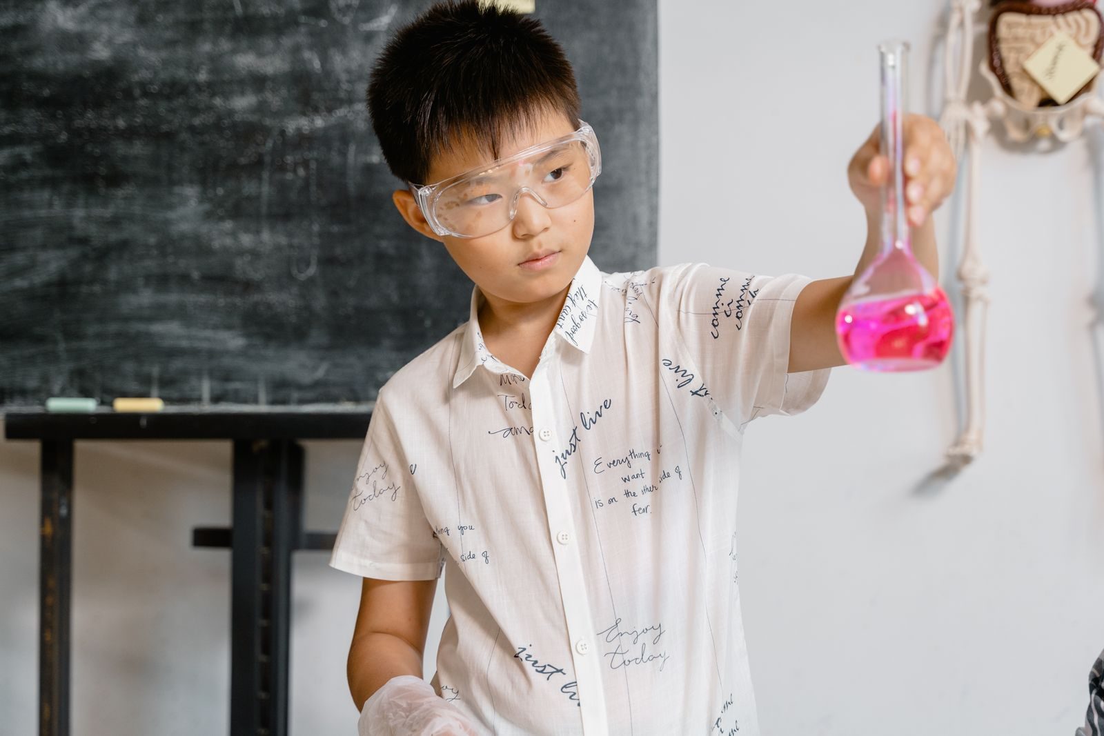 Boy holding up a flask during a hands-on science workshop